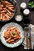 Portion of Italian pasta 'Tortiglioni' with tomato sauce, on wooden table. View from above.