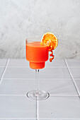 Blood Orange Margarita on a tiled table with a grey background