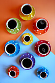 Colourful cups with black coffee. Retro colour block aesthetic.