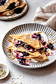 Paleo gluten-free almond flour crepes with berry compote and cream