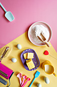 Modern baking concept flatlay with retro pink and yellow colour blocking aesthetics.