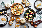 Autumnal feast with quiche, salad and pumpkins