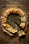 Bean cake with spinach flavour on a warm wooden background. View from above.
