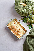 Autumn cake with pumpkin filling on unleavened dough, large green pumpkin, view from above