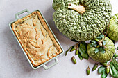 Autumn cake with pumpkin filling on unleavened dough, large green pumpkin, view from above