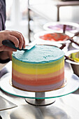 Prepare the rainbow cake: Smooth the buttercream with a palette knife