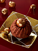 Small chocolate bundt cake with gilded mini apples