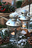 Winterliche Deko mit Laternen, Holzsternen, Zapfen und Scheinbeere im Freien