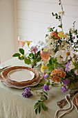 Frühlingshaft gedeckter Tisch mit buntem Blumenarrangement