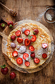 Crêpes with strawberries and icing sugar