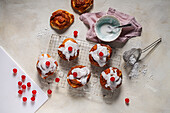 Sweet almond and yeast dough swirl with icing and candied cherries