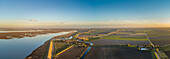 Panoramaluftaufnahme eines kleinen Dorfes, das von einem Hochwasserschutzwall umgeben ist, Niederlande.