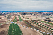 Aerial view of the colorful field with wind turbines, in the Wienerwald, Austria