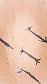 Aerial view of Four friends playing with shadow on the beach in Brazil.
