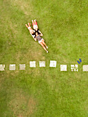 Aerial view of three girls lying in the garden during summer.