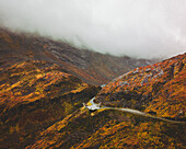 Aerial view of an abstract sculpture along the road on the mountain with fog, Norway.