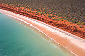 Aerial view of beautiful Bottle Bay with sandy beach, turquoise water, and red cliffs, Denham, Australia.