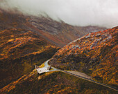Aerial view of an abstract sculpture along the road on the mountain with fog, Norway.