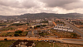 Aerial view of a beautiful urban landscape with residential buildings and construction sites amidst hills, Abuja, Nigeria.