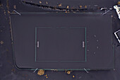 Aerial view of a soccer field covered with ashes from Cumbre Vieja eruption, a Volcano in La Palma island, Canary Islands, Spain.