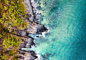 Aerial view of surfers along Tea Tree Bay coast in Noosa National Park near Noosa Heads town, Sunshine Coast, Queensland, Australia.