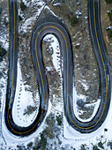 Aerial view of Lookout Mountain roadway, snow melting, black pavement, top down view in Golden, Colorado.