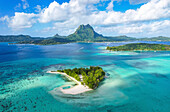 Aerial view of beautiful tropical island coastline with blue ocean and reef, Motu Tapu, Bora Bora, French Polynesia.