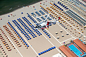 Tuscany, Italy - 16 July 2018: Aerial view of an AW 139 Agusta helicopter of the Italian Coast Guard flying over the beaches of Versilia during surveillance from above, Tuscany, Italy.