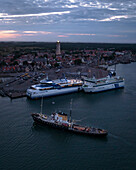 Terschelling, Niederlande - 25. Juli 2022: Luftaufnahme eines schönen Sonnenuntergangs über dem Hafen mit Fähren und Schleppern im Wasser, Terschelling, Niederlande.