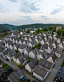 Aerial view of picturesque half-timbered houses in a charming village surrounded by hills and trees, Freudenberg, Germany.