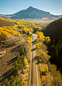 Aerial view of an endless road driving along Coal Creek with Crested Butte mountain in background, Crested Butte, Colorado, United States of America.