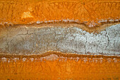 Aerial view of abstract redbank salt farm with cracked earth patterns in earthy tones, Port Hedland, Australia.