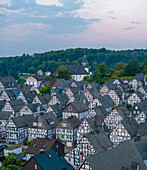 Aerial view of picturesque half-timbered houses and lush greenery at sunrise, Freudenberg, Germany.