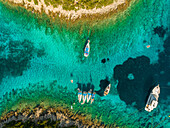 Luftaufnahme einer Gruppe von Booten, die zwischen Inseln vor Anker liegen, Ithaki, Griechenland.