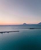 Luftaufnahme eines Fischerboots am Horizont bei Sonnenuntergang vom Yachthafen in Patras, Griechenland