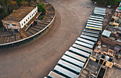 Gurugram, India - 16 April 2020: Aerial view of a line of public buses parked in a parking lot in Gurugram during lockdown, Haryana state, India.