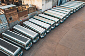 Gurugram, India - 16 April 2020: Aerial view of a line of public buses parked in a parking lot in Gurugram during lockdown, Haryana state, India.