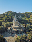 Aerial view of the historic moulin de Collioure on a hillside surrounded by greenery and trees, Collioure, France.
