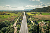 Aerial view of empty asphalt road in the countryside with the mountains on the horizon