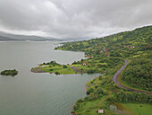 Aerial view of a road by the Pawna lake on a cloudy day in Lonavala city of Maharashtra state in India.
