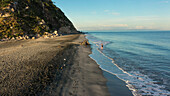 Luftaufnahme eines ruhigen Strandes mit felsigen Klippen und sanften Wellen, Santa Marta, Magdalena, Kolumbien.