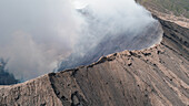 Aerial view of a man standing of the edge of mount Bromo in east of Java island, Indonesia.