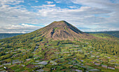 Luftaufnahme des Berges Batur an einem bewölkten Tag mit Blick auf das Dorf Pinggan im Norden Balis, Indonesien.