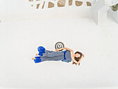 Aerial view woman lying on the roof on Santorini, Greece.