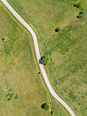 Aerial view of white car on asphalt road in the countryside, Greece