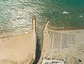 Aerial view of beach with river entering sea with straw parasols on Achaia, Greece.