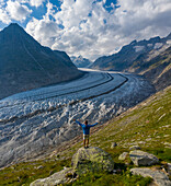 Aerial view of a person standing in front of the Aletsch Glacier, Valais, Switzerland.
