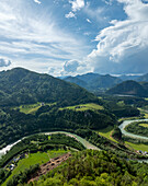 Luftaufnahme des ruhigen Flusses Enns, der sich durch üppig grüne Täler und majestätische Berge schlängelt, Landl, Österreich.