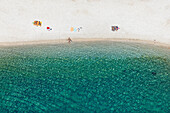 Aerial view of serene beach with crystal clear turquoise water and sunbathers, Lungomare, Pula, Croatia.