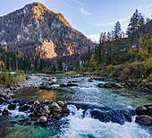 Aerial drone view of Salza River with a mountain peak in the background on a fall day under a clear sky surrounded by a forest, Wildalpen, Austria.